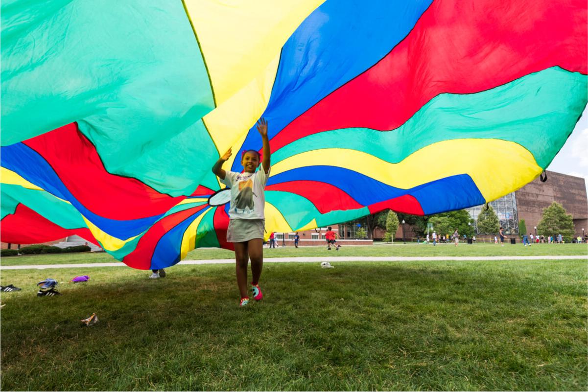 Young child runs under parachute at University of Rochester